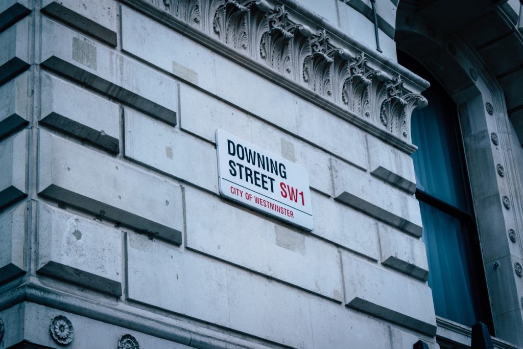 A street sign for London's famous Downing street is in position upon a fancy-looking wall