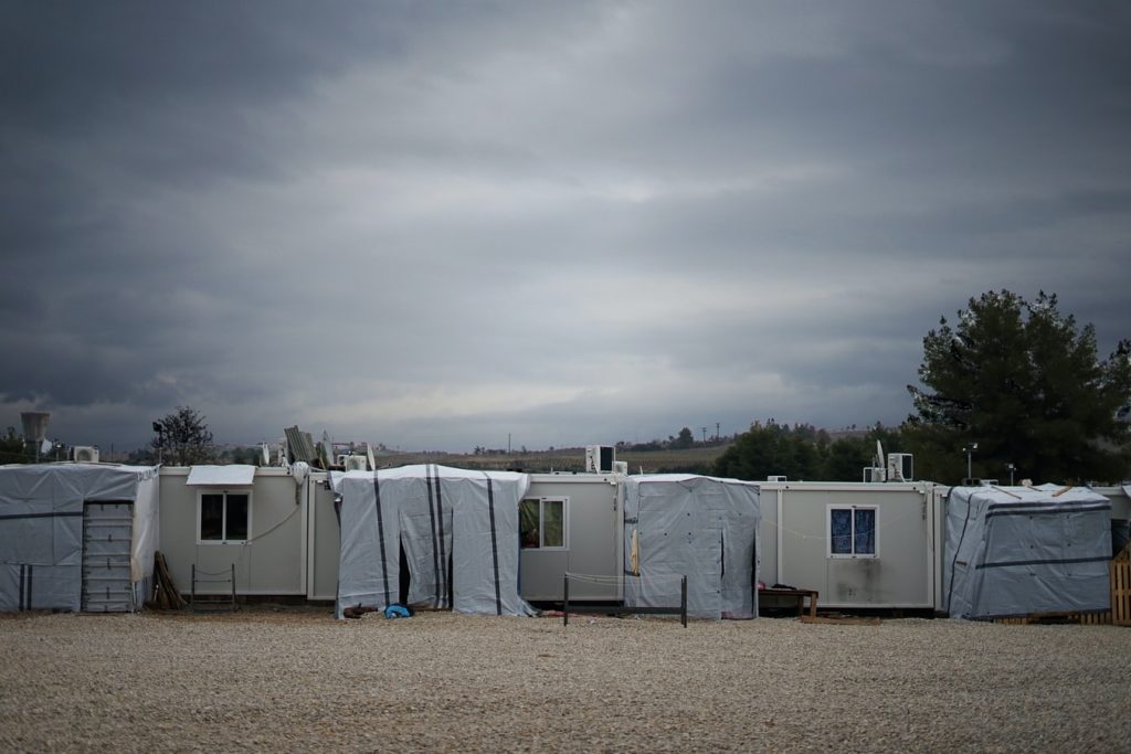 Temporary structures at a refugee camp under a grey sky