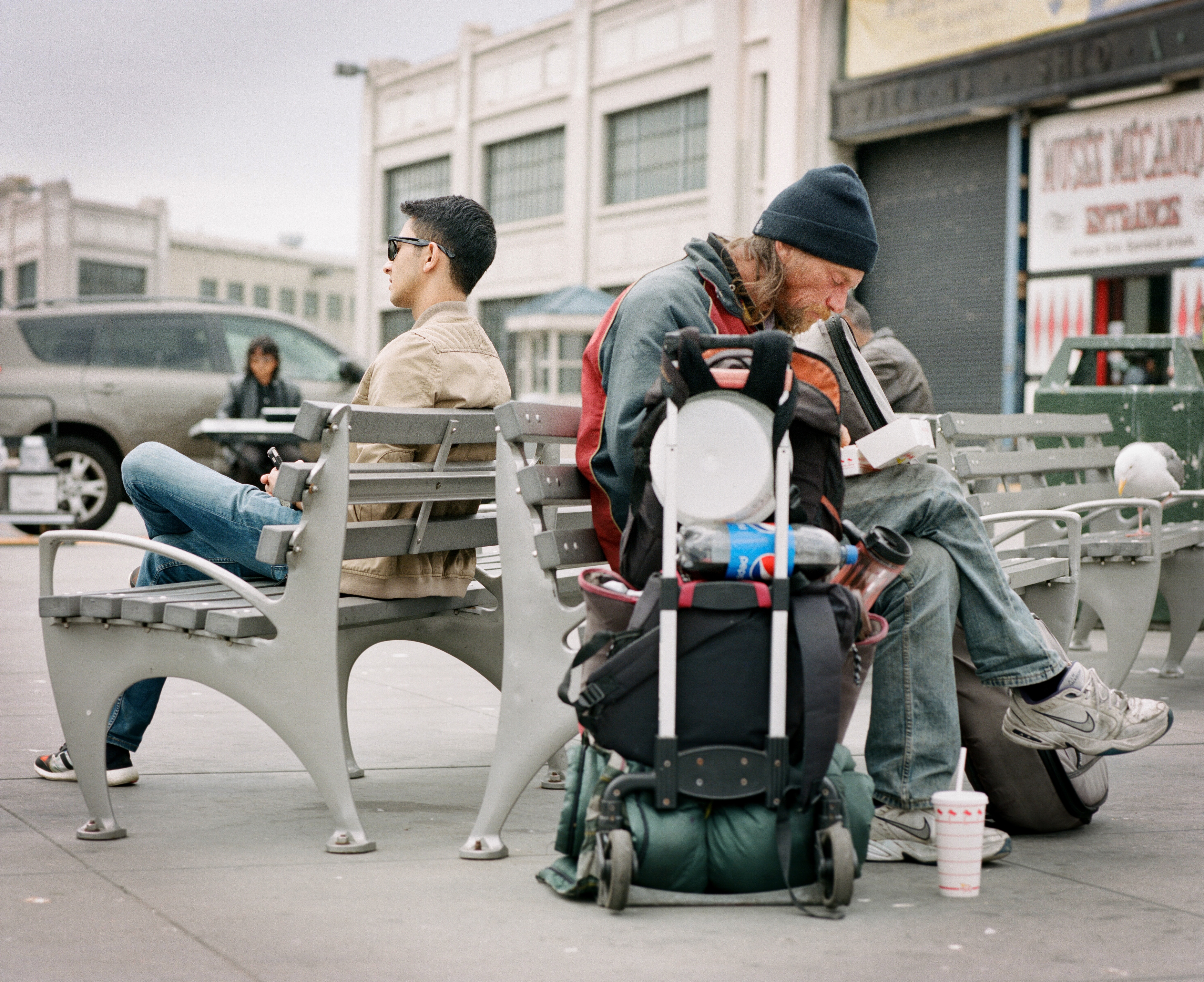 benjamin-disinger-2xzEIQFzw0g-unsplash Hungry homeless man sits behind wealthy young man