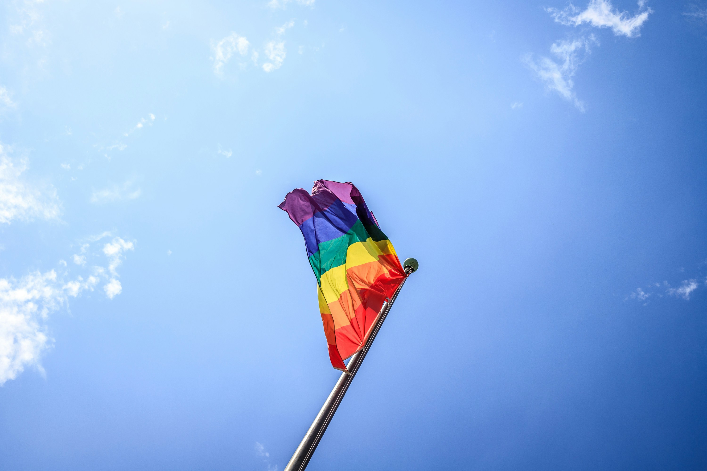 3rd tim-bieler-8WgQ_DIEBJY-unsplash An LGBTQ flag in the blue sky
