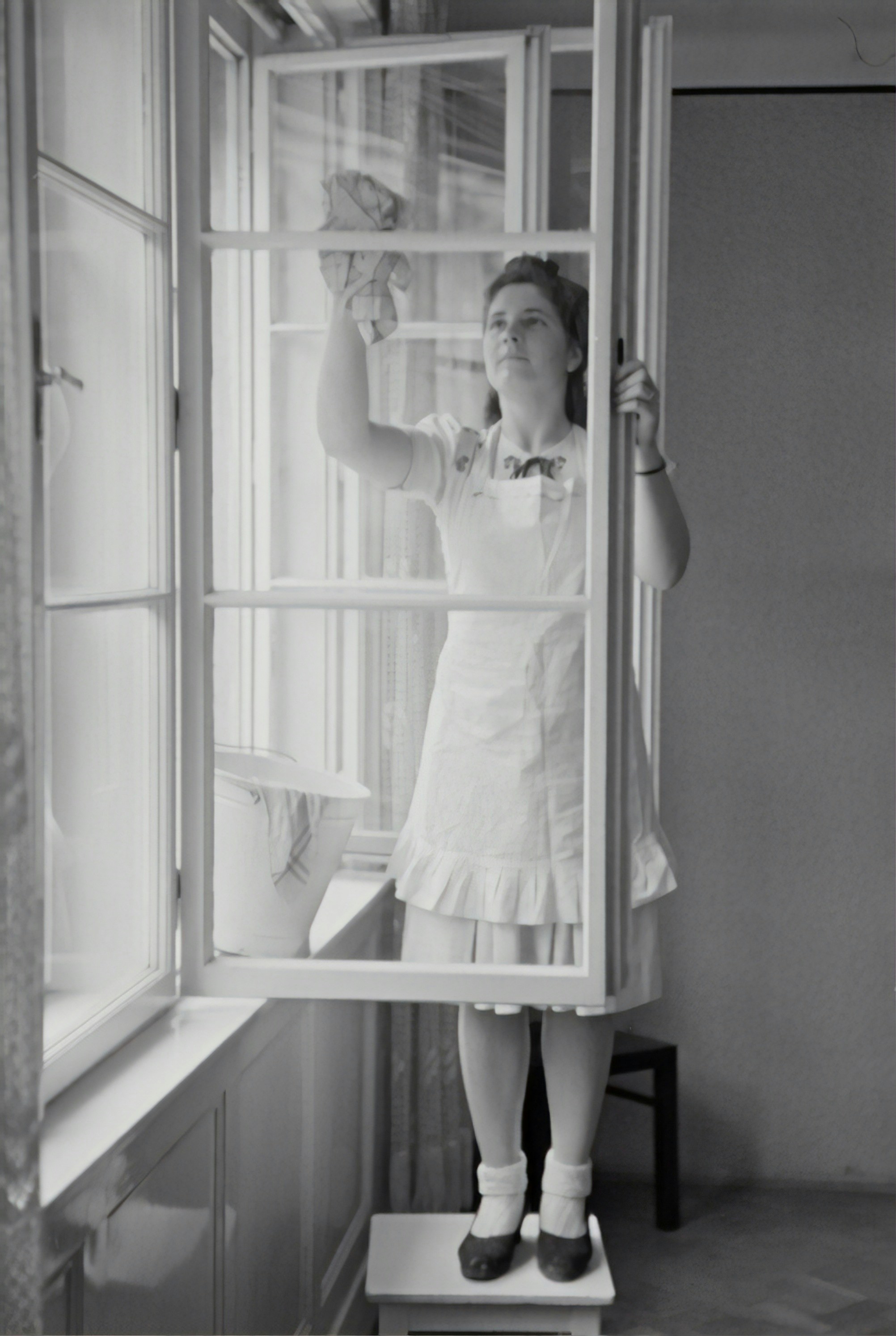 Amira-Nadia austrian-national-library-t5qnrCVkUz8-unsplash A black and white picture of a woman washing a window