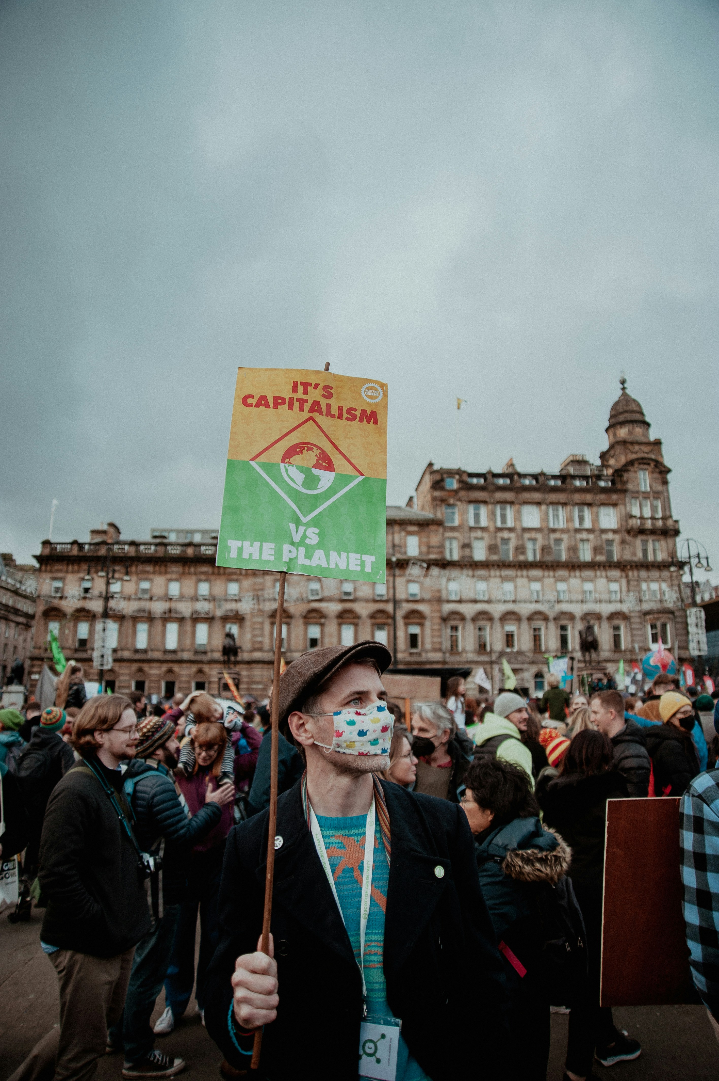 Laurie william-gibson-t2mT_ziuuPg-unsplash A man holding a sign saying it's capitalism or the planet