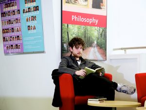 Male student reading in a study space