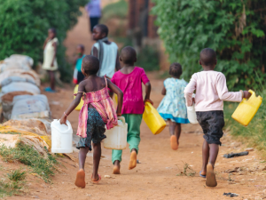 Children running with water cans in hand