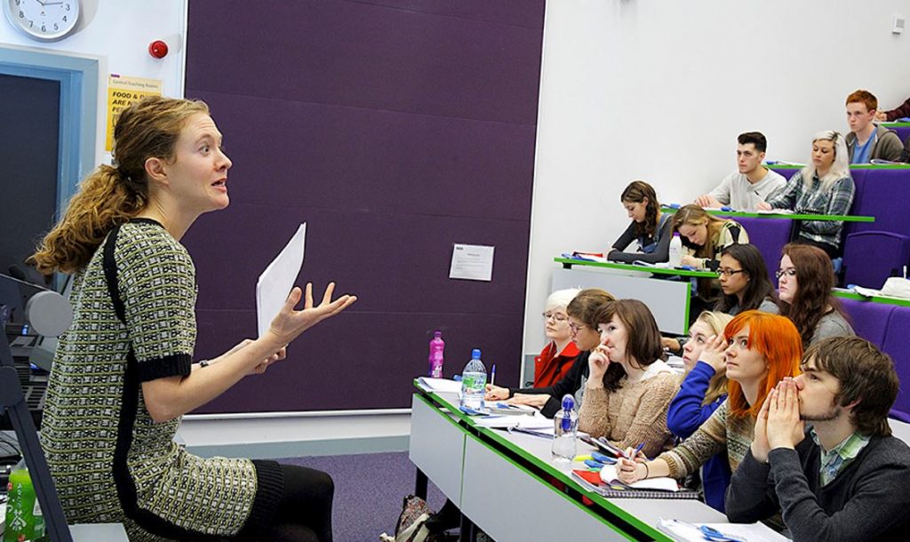 Woman teaching a lecture hall of students