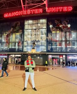 Man standing in front of a Manchester United sign