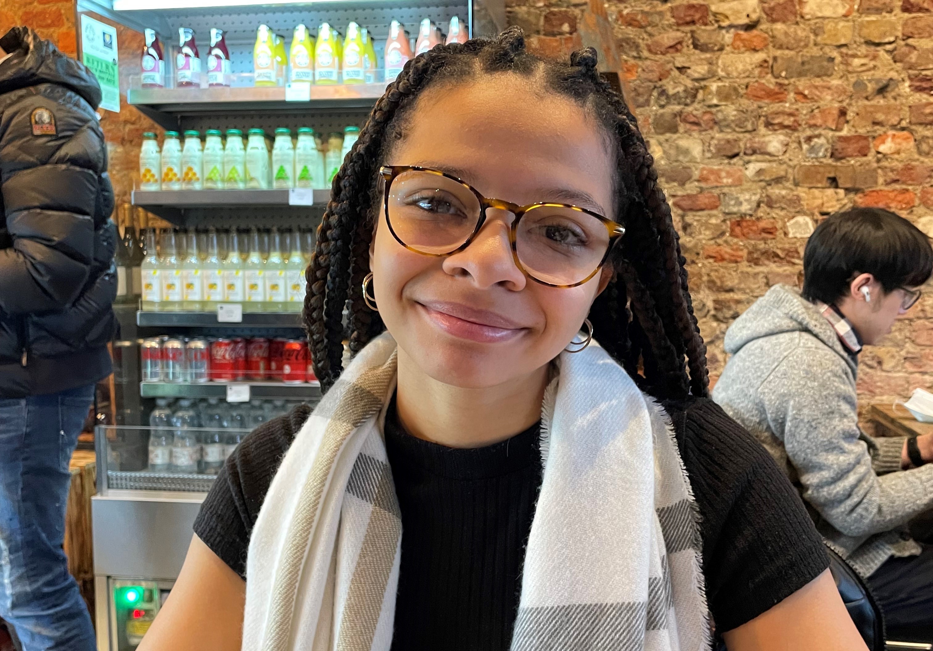 Girl sat in a cafe smiling at camera
