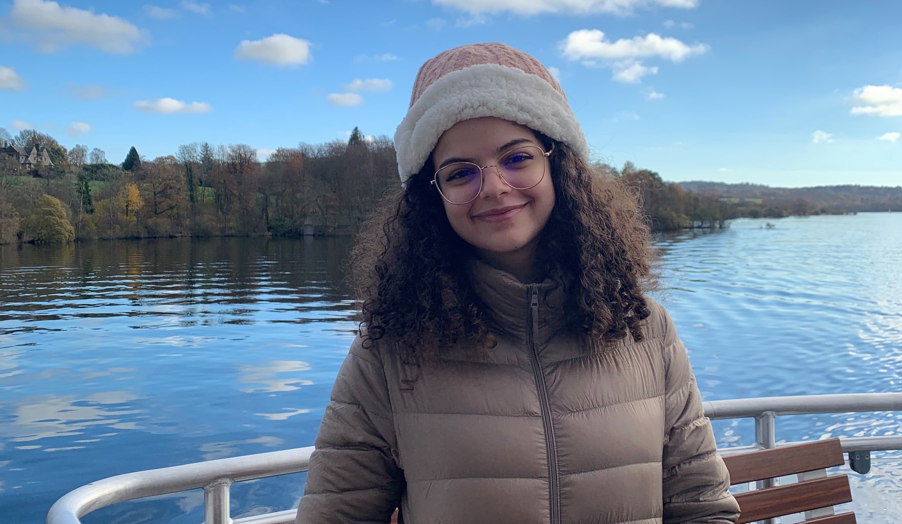Salma smiling in front of a body of water