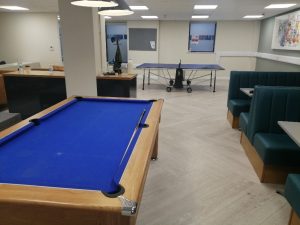Room with sofas, a pool table and a ping pong table