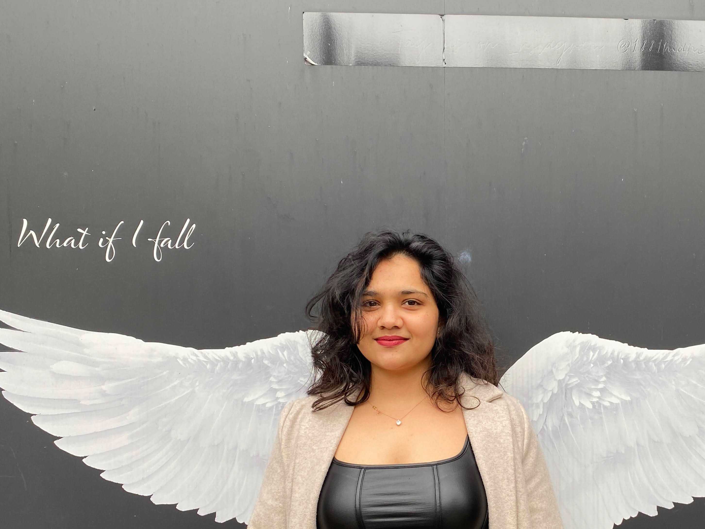 Student infront of painting with wings