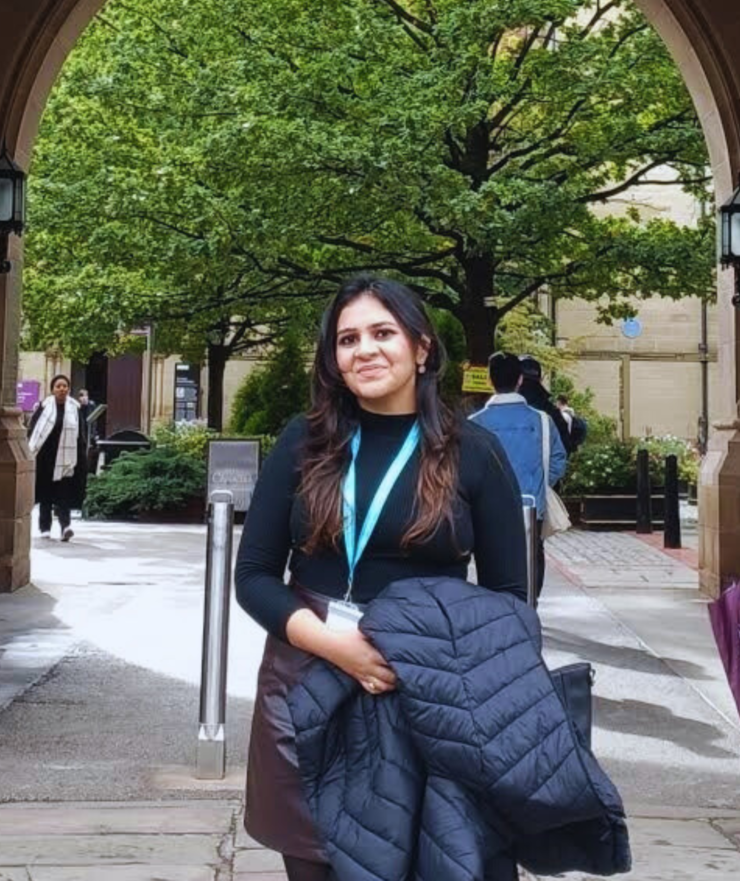 Student, Rani, stands under the arches of the old quad on campus