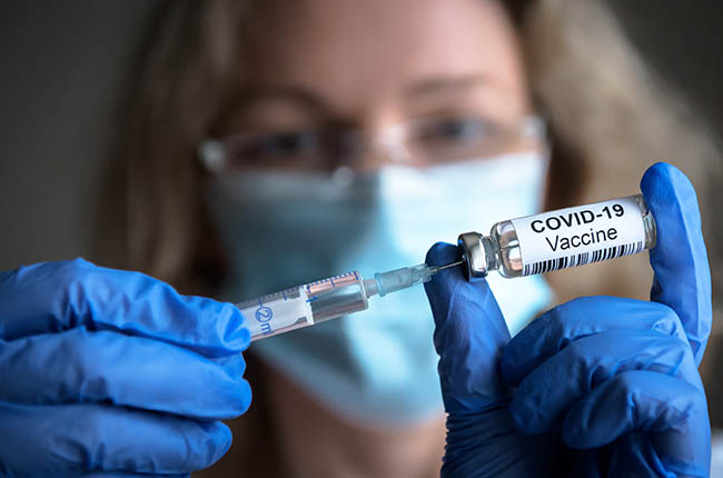 A nurse prepares to give a COVID-19 vaccination.