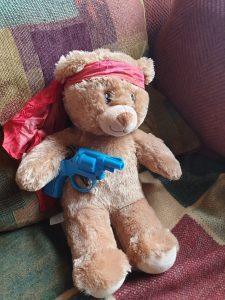 teddy bear with a toy gun