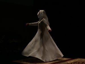 Woman dressed in white, dancing a Sufi Dance, which is an expression of spirituality, on stage