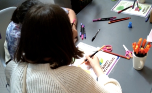 A child doing an activity with colours and paper.