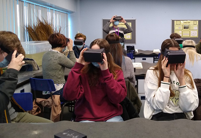 Class of students using VR goggles
