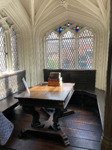 Alcove with arched windows, wooden seating and table.