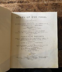 The Communist Manifesto book, showing a page of text entitled State of the Poor.